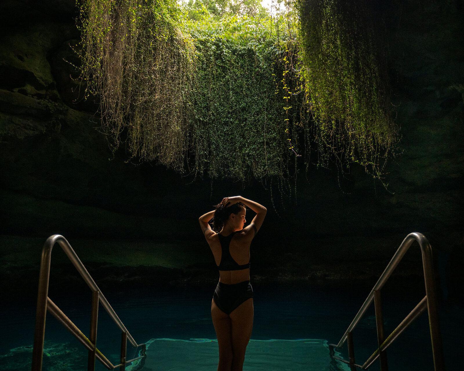 Vine-draped entrance to Devil's Den Spring in Williston, Florida, seen from the staircase